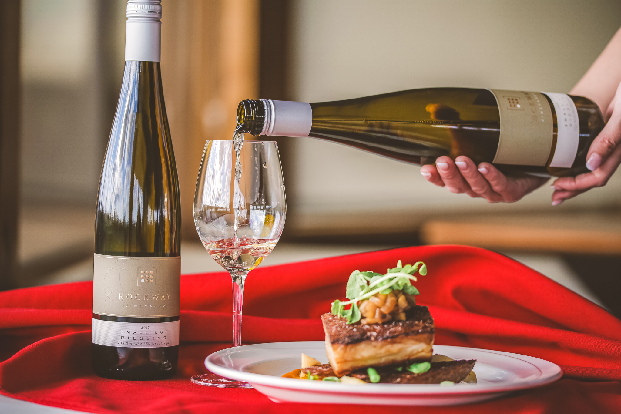 white wine being served by a plate of food